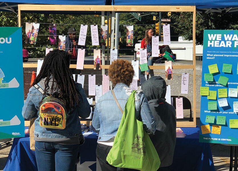 Pop up tabling session for the Central Library project where three people are interacting with the materials displayed