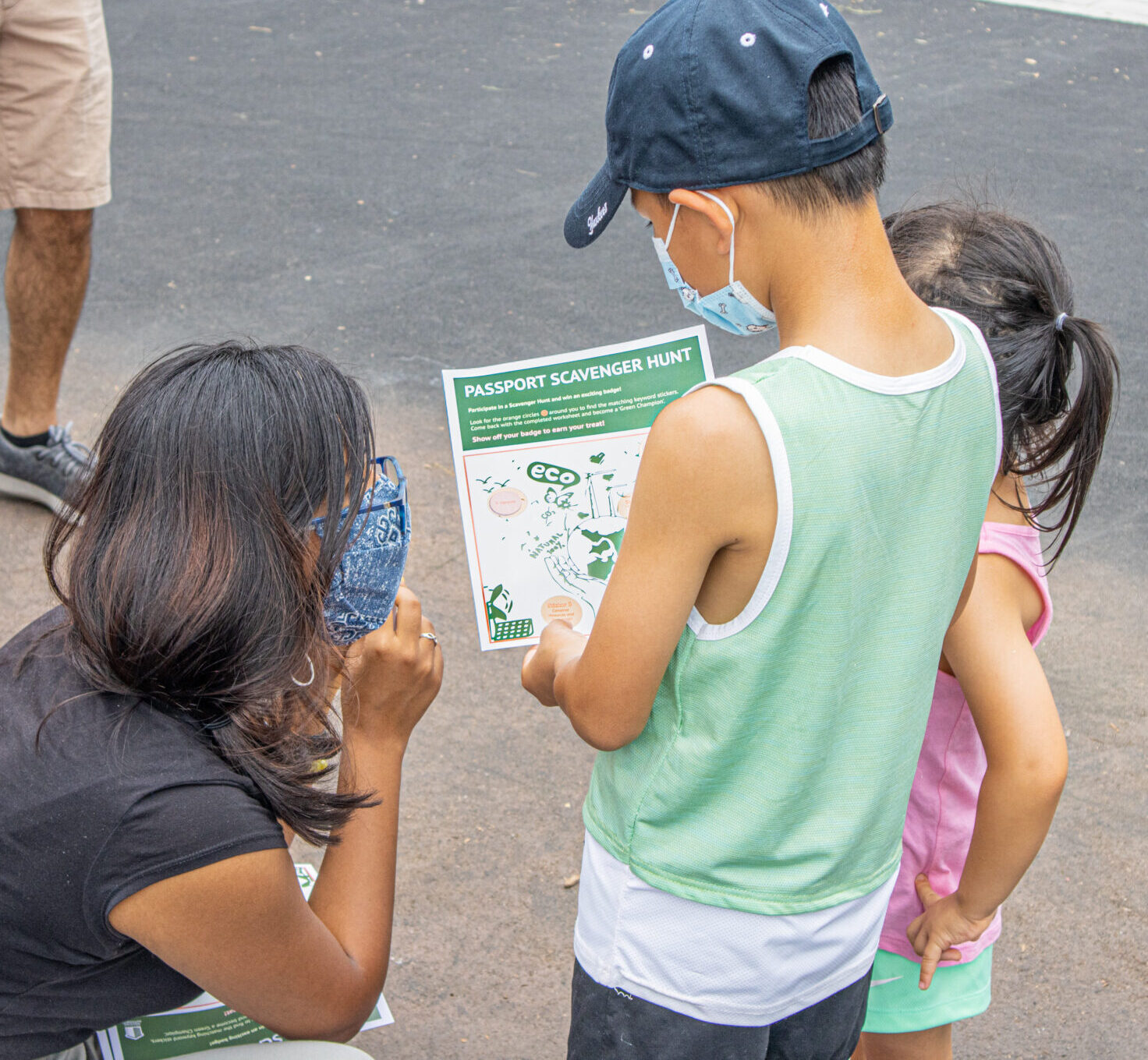 A facilitator explaining the scavenger hunt activity to a kid at a NYCHA family day