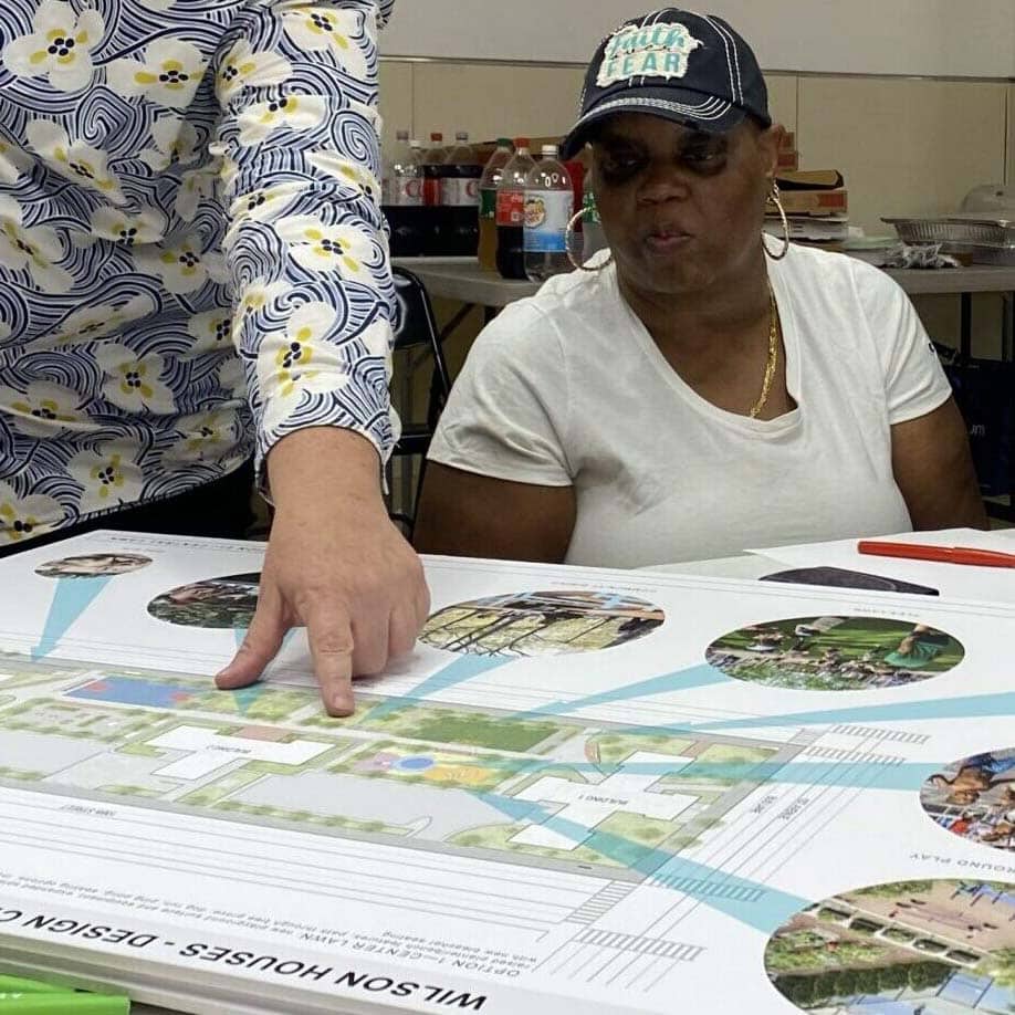People sitting at a table and discussing the upgrades for their apartments and development under the PACT program